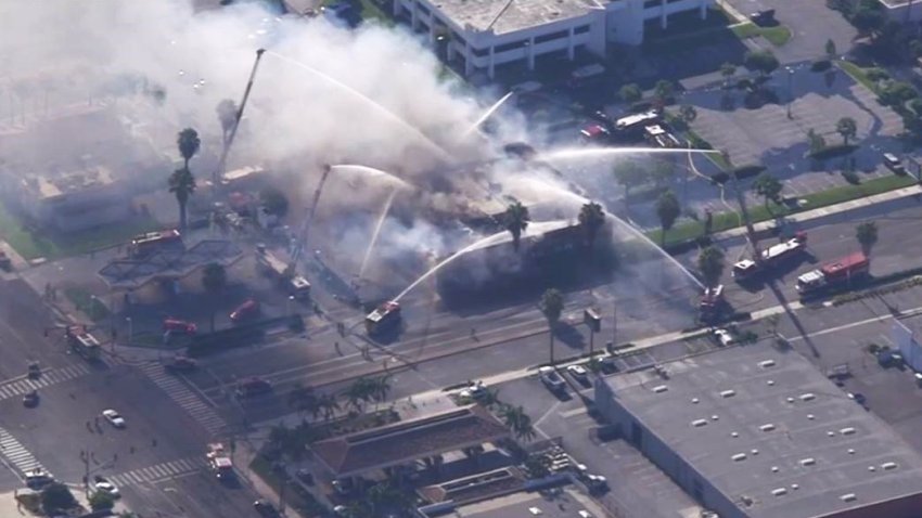 Firefighters spray water on flames Wednesday Aug. 14, 2024 at an Anaheim business complex.