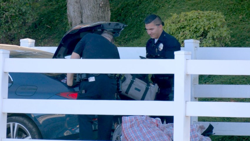 LAPD officers from the Devonshire Area search a Mercedes sedan after it crashed during a pursuit Thursday afternoon in Porter Ranch. The occupants were suspected of burglarizing a nearby home.