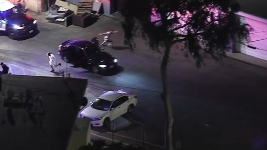 Passengers jump out of a car during a car chase in Pacoima on Wednesday, Aug. 21, 2024.