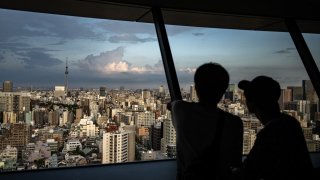 People look at the city’s skyline from the Bunkyo Civic Center Observation Deck in Tokyo on August 14, 2024. 