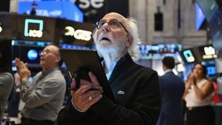 Traders work on the floor of the New York Stock Exchange during morning trading on Aug. 23, 2024.