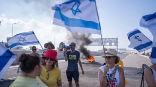 Family, friends and supporters of Israeli hostages taken by Hamas in Gaza take part in a protest on the Israeli costal road outside Kibbutz Yakum. 