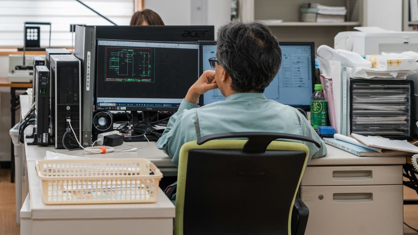 An office worker studying electronic diagrams on a computer at control-panel maker in Japan.