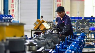 A worker assembling a loader transmission mechanism at a manufacturer in Qingzhou, China.