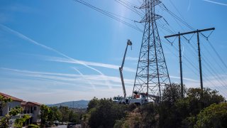 High lift bucket with a electrical worker performing maintenance on electrical grid.