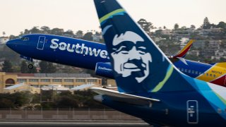 FILE - A Southwest Airlines Boeing 737-8 jet departs from San Diego International Airport past an Alaska Airlines jet