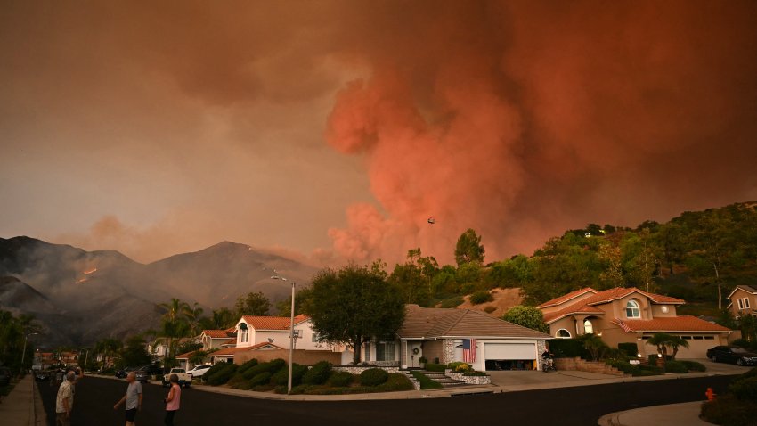 TOPSHOT – Smoke from the Airport Fire billows above homes in Rancho Santa Margarita, California, on September 9, 2024. Wildfires fueled by soaring temperatures in the western United States have scorched thousands of acres, forcing hundreds of families to flee, US officials said September 9, 2024. (Photo by Patrick T. Fallon / AFP) (Photo by PATRICK T. FALLON/AFP via Getty Images)