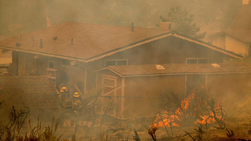 Wrightwood, CA – September 11: San Bernardino County firefighters work to save a home in Wrightwood as they battle the Bridge Fire amid high temperatures in Wrightwood Wednesday, Sept. 11, 2024.  (Allen J. Schaben / Los Angeles Times via Getty Images)