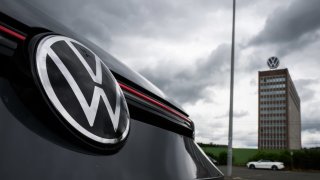 A VW Golf GTI stands in a parking lot within sight of the brand tower on the grounds of the VW plant in Wolfsburg, Germany.