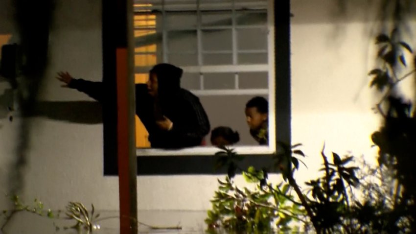 A woman reaches out window during hurricane milton