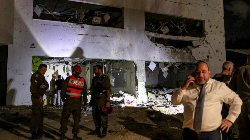 Members of Israel’s Home Front Command and police forces inspect a crater left by an exploded projectile at a heavily-damaged school building in Israel’s southern city of Gedera on October 1, 2024, after Iran launched a barrage of missiles at Israel in response to the killings of Lebanese Hezbollah leader Nasrallah and other Iran-backed militants. Reports said Iran fired between 150 and 200 missiles in the attack, the country’s second on Israel after a missile and drone attack in April in response to a deadly Israeli air strike on the Iranian consulate in Damascus. (Photo by Menahem KAHANA / AFP) (Photo by MENAHEM KAHANA/AFP via Getty Images)