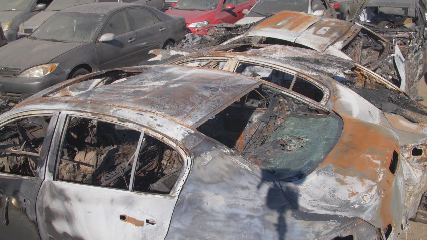 A row of burned Infiniti sedans is seen at a tow yard in the San Fernando Valley on Tuesday.