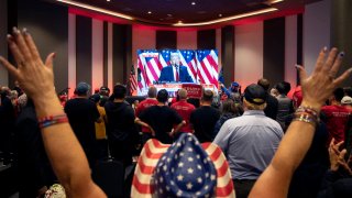 Attendees cheer as a broadcast of former US President and Republican presidential candidate Donald Trum speaking at his Florida election party is shown on a screen at the Nevada GOP election watch party in Las Vegas, Nevada on November 6, 2024. 