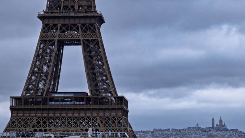 This photograph shows part of the Eiffel Tower with the Sacre-Coeur Basilica in the background, in Paris, on November 27, 2024. 