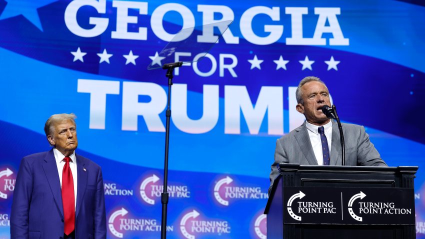 Robert F. Kennedy Jr. speaks as Republican presidential nominee, former U.S. President Donald Trump looks on during a Turning Point Action campaign rally at the Gas South Arena on October 23, 2024 in Duluth, Georgia.