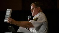 Barry County Sheriff Dar Leaf, from Michigan, with a book titled “The 2020 Coup” during a press conference in Las Vegas in 2022