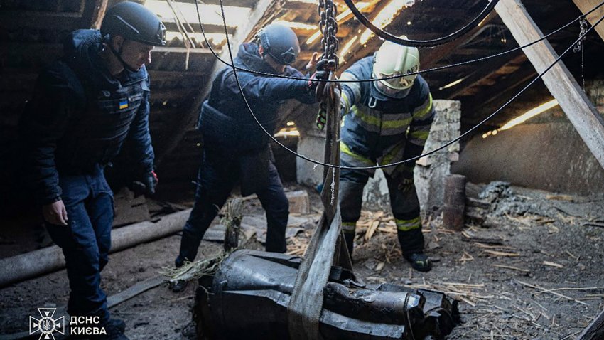 In this photo provided by the Ukrainian Emergency Service, emergency services personnel remove part of a Russian missile that hit an apartment house during massive missile attack in Kyiv, Ukraine, Sunday, Nov. 17, 2024.