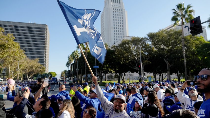 Nov 1, 2024; Los Angeles, CA, USA; A fan waves a flag to support the Los Angeles Dodgers before the 2024 World Series championship parade near Los Angeles City Hall. Mandatory Credit: Kirby Lee-Imagn Images