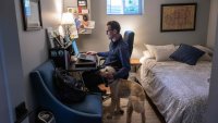 Danny Crouch pets his dog as he sits in his basement working from home in Arlington, Virginia, on May 25, 2023. The pandemic forced Americans to work from home. And now, more than three years on, employers are struggling to bring them back to the office.