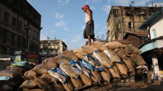 A laborer loads consumer goods onto a supply cart at a wholesale market in Kolkata, India, on November 11, 2024.