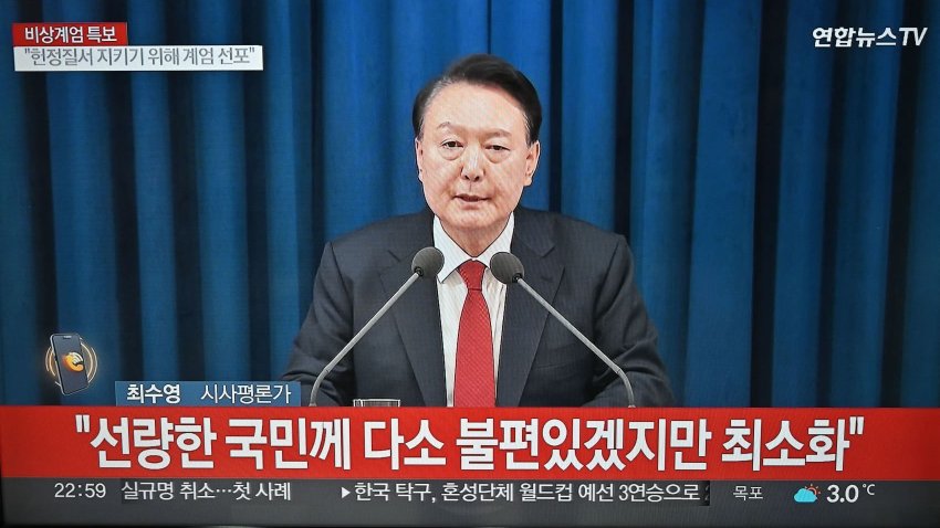 A television screen shows a news broadcasting of South Korean President Yoon Suk Yeol delivering a speech on emergency martial law, in Goyang, northwest of Seoul, on December 3, 2024.