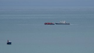 A boat thought to be with migrants is escorted by a vessel from the French Gendarmerie Nationale