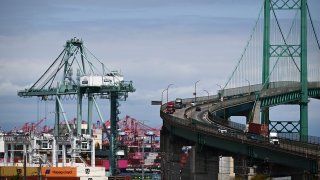 A truck crosses the Vincent Thomas Bridge as cargo shipping containers are unloaded from a container ship at the Port of Los Angeles in Los Angeles, California on June 7, 2023. (Photo by Patrick T. Fallon / AFP) (Photo by PATRICK T. FALLON/AFP via Getty Images)