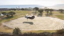 MALIBU, CA - DECEMBER 10: A Los Angeles County fire helicopter picks up water from a pond at Pepperdine University while fighting the Franklin fire in Malibu, CA on Tuesday, Dec. 10, 2024. (Myung J. Chun / Los Angeles Times via Getty Images)