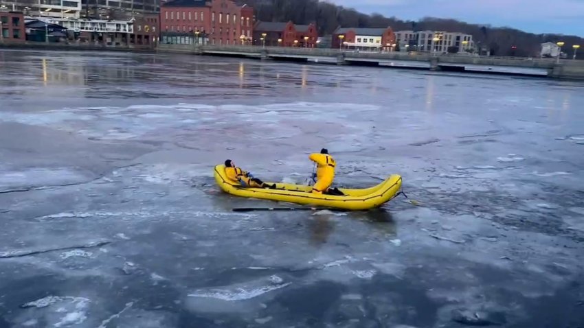 Firefighters in a raft on a frozen river.