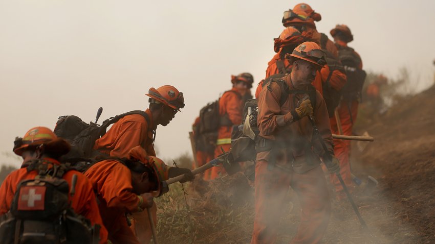 Inmate firefighters dig a containment line as they battle the Palisades Fire on Jan. 11, 2025 in Los Angeles.