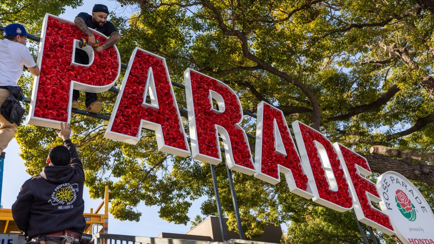 Crews put up a Rose Parade banner above the grandstands along Orange Grove Blvd. as thousands of people arrive early and set up their viewing area New Year’s Eve to hold their spots before Wednesday’s Rose Parade in Pasadena Tuesday, Dec. 31, 2024.