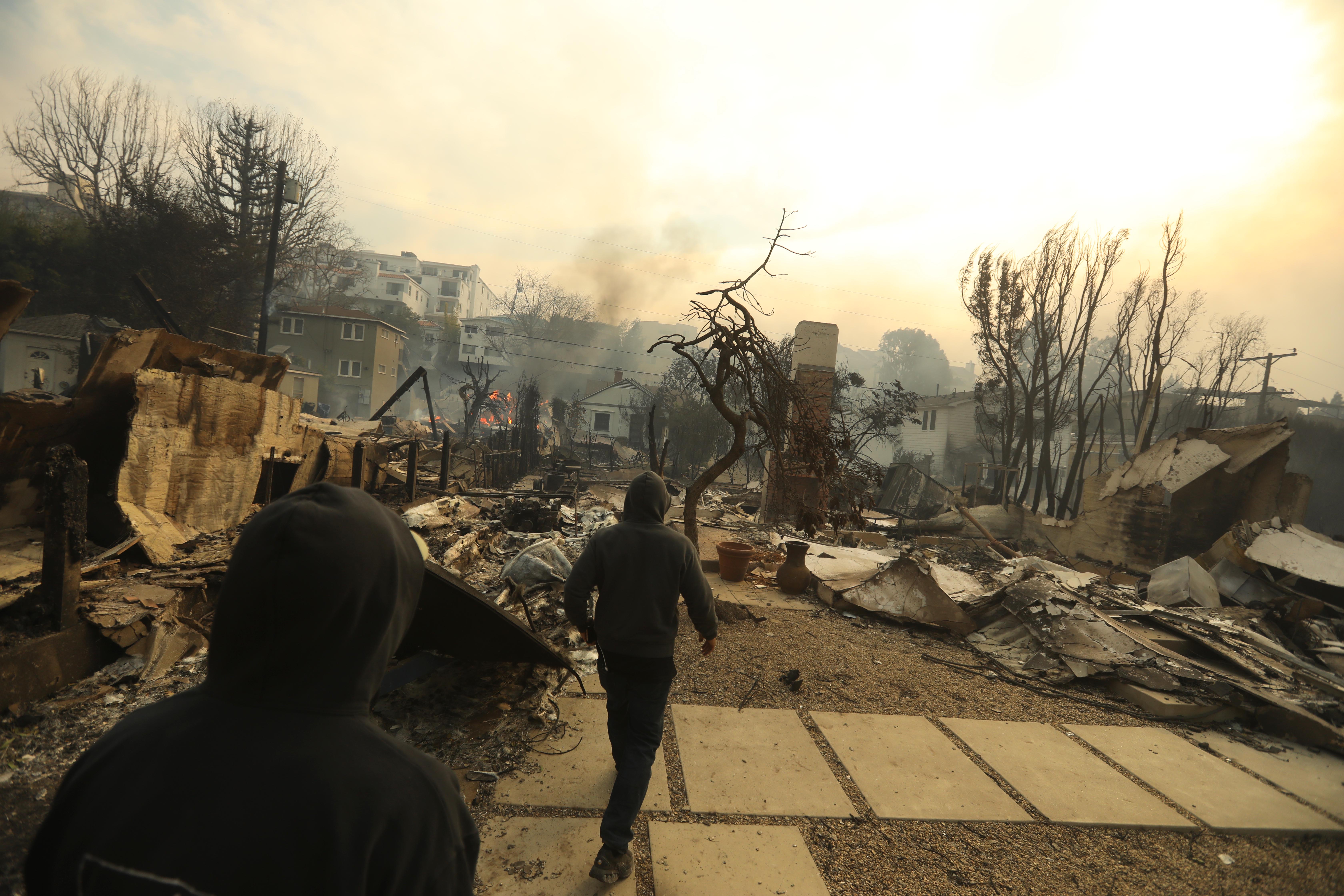 Brothers Glenn Watson, left, and his brother Wes, return to their Pacific Palisades neighborhood to view the damage from the Palisades fire on January 7, 2025.