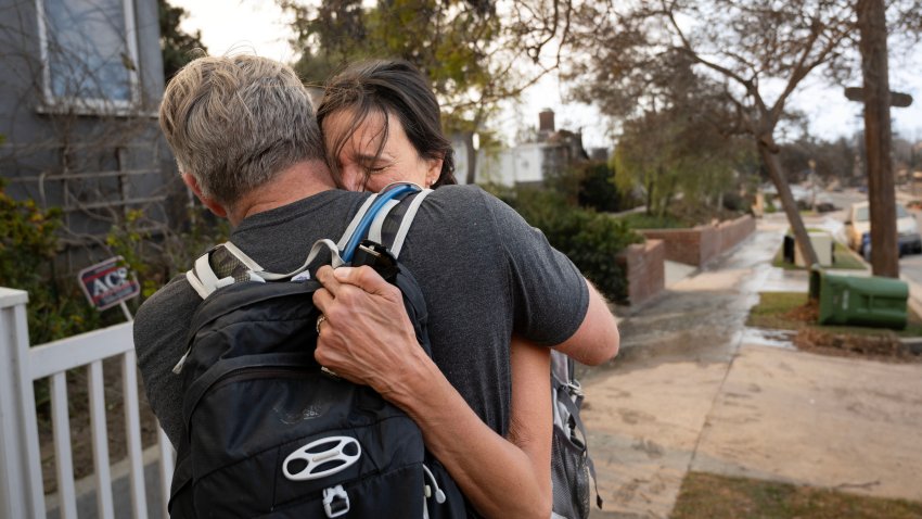 Pacific Palisades, CA – January 11: Anita Bajpai hugs her husband, Brett Peterson, after discovering on Saturday, January 11, 2025, that her 1940s-era childhood home survived the Pacific Palisades fires. Maps indicated it was in the fire zone but only a garage apartment in the back was destroyed. Bajpai’s mother, who is safe, lives there now. The couple are from Orange County.(Photo by Mindy Schauer/MediaNews Group/Orange County Register via Getty Images)