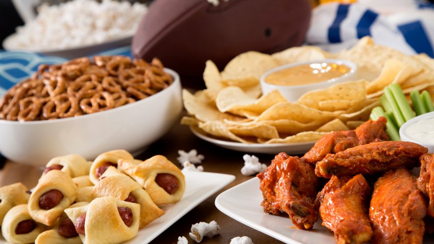 Hot wings, nachos, pigs in a blanket, beer, and popcorn, a tailgate party spread.  Please see my portfolio for other food and drink images.