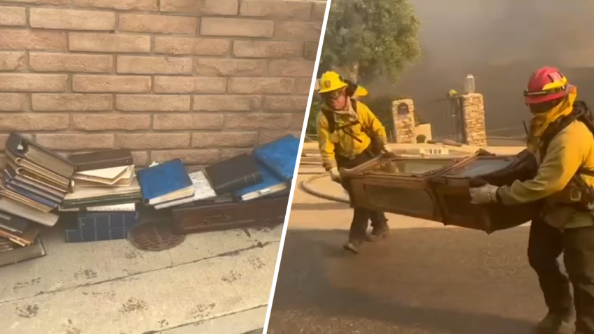 Firefighters retrieve photo albums and a grandfather clock from a burning home in Pacific Palisades on Tuesday, Jan. 7, 2025.