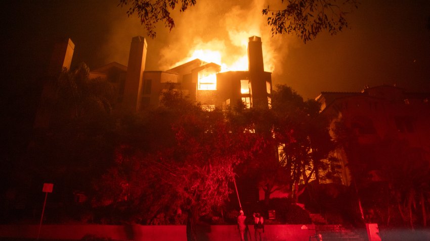 LOS ANGELES, CALIFORNIA – JANUARY 9: Flames from the Palisades Fire burn a residential building on Sunset Boulevard amid a powerful windstorm on January 9, 2025 in the Pacific Palisades neighborhood of Los Angeles, California. Multiple wildfires fueled by intense Santa Ana Winds are burning across Los Angeles County. At least five people have been killed, and over 25,000 acres have burned. Over 2,000 structures have also burned and almost 180,000 people are under orders to evacuate. (Photo by Apu Gomes/Getty Images)