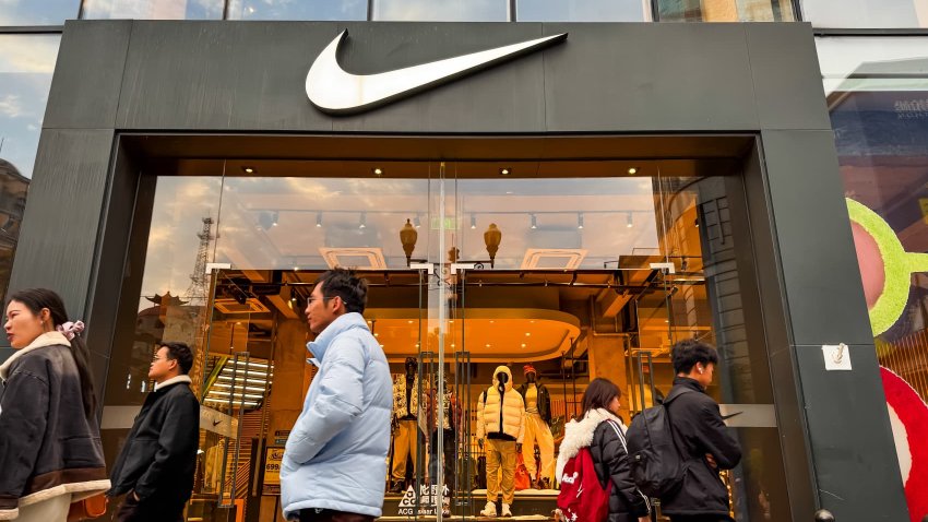 Pedestrians walk past a Nike store featuring a modern design and mannequins displaying winter apparel on December 5, 2024, in Wuhan, Hubei Province, China. 