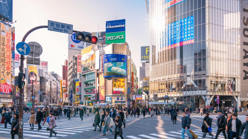 Pedestrians walking across a crowded traffic at Shibuya crossing square in Tokyo, Japan.