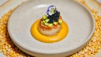 Gourmet scallop dish with edible flower and caviar garnish