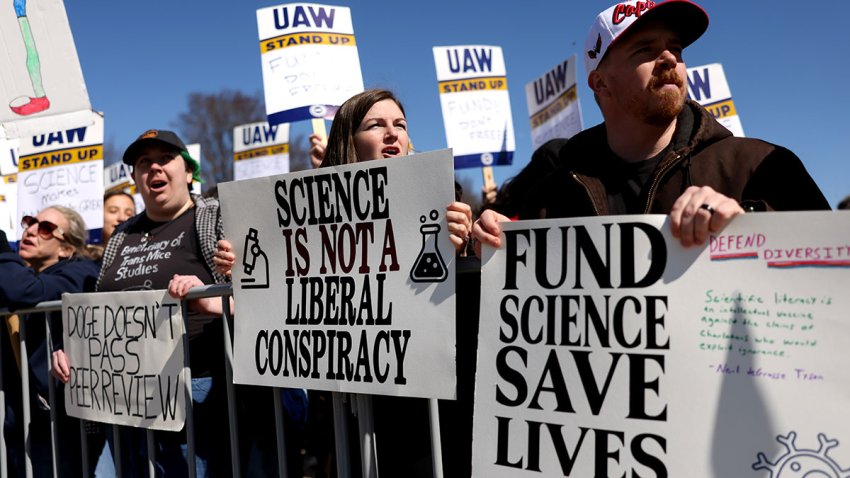 Demonstrators hold signs during a Stand Up For Science rally at the Lincoln Memorial on Friday, March 7, 2025. A federal judge issued a nationwide block against the Trump administration’s moves to slash funds from the National Institutes of Health that cover grant recipients research overhead costs, dealing a blow to one of the government’s efforts to reduce spending.