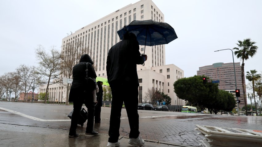 Los Angeles, CA – March 11: Pedestrians navigate the rain as they cross the street in downtown Los Angeles Tuesday, March 11, 2025.  (Allen J. Schaben / Los Angeles Times via Getty Images)