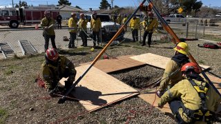 Firefighters work to rescue a gas company worker who fell into a well Monday March 3, 2025 in Hesperia.