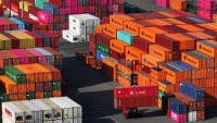 In this aerial view a forklift drives among stacked shipping containers in Hamburg Port on April 15, 2025 in Hamburg, Germany.