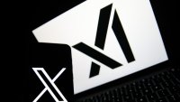 The X logo appears on a phone, and the xAI logo is displayed on a laptop in Krakow, Poland, on April 1, 2025. (Photo by Klaudia Radecka/NurPhoto via Getty Images)