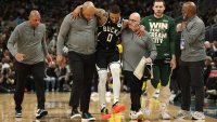 Damian Lillard of the Milwaukee Bucks is helped off the court