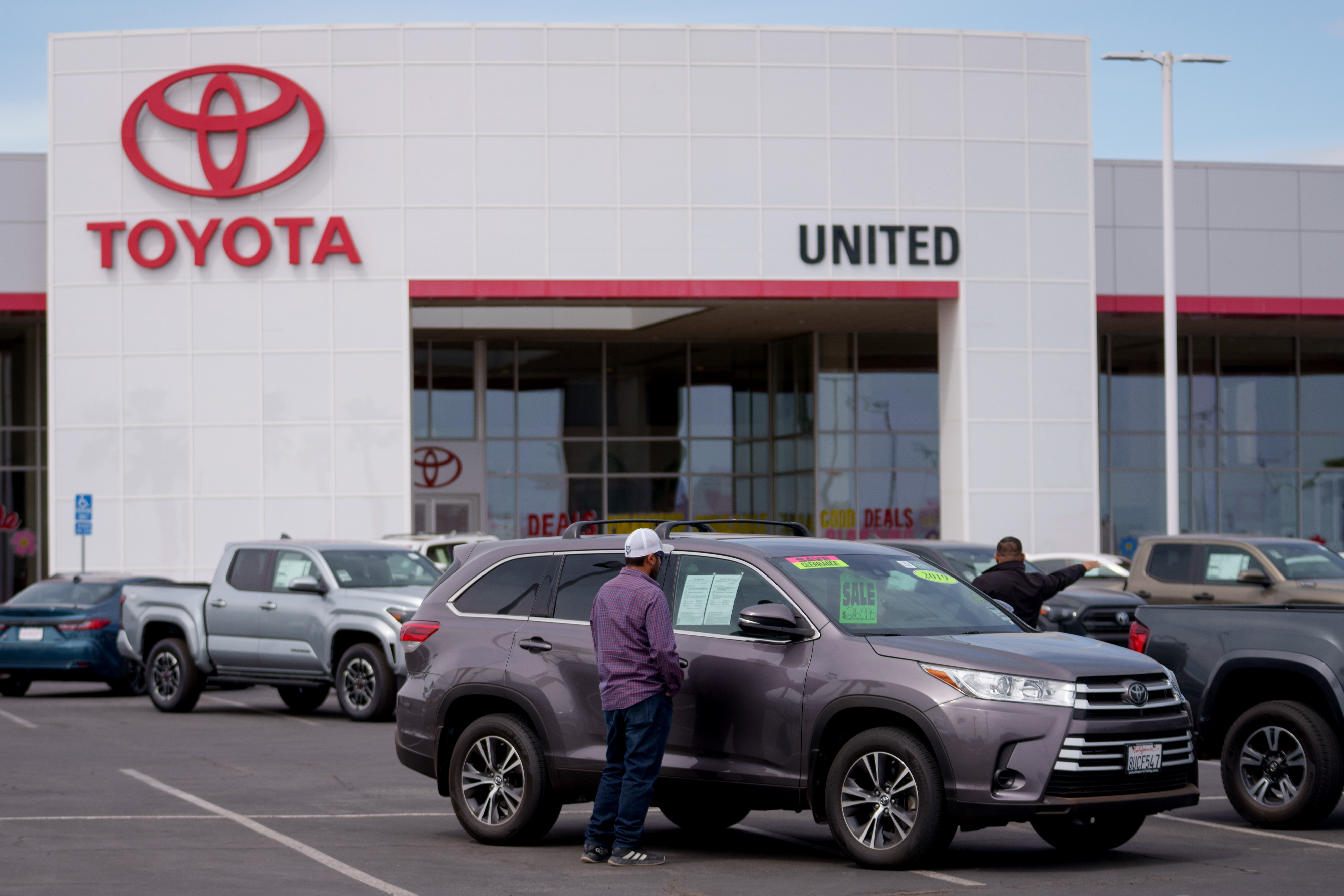 A customer looks at a used vehicle for sale at a Toyota dealership