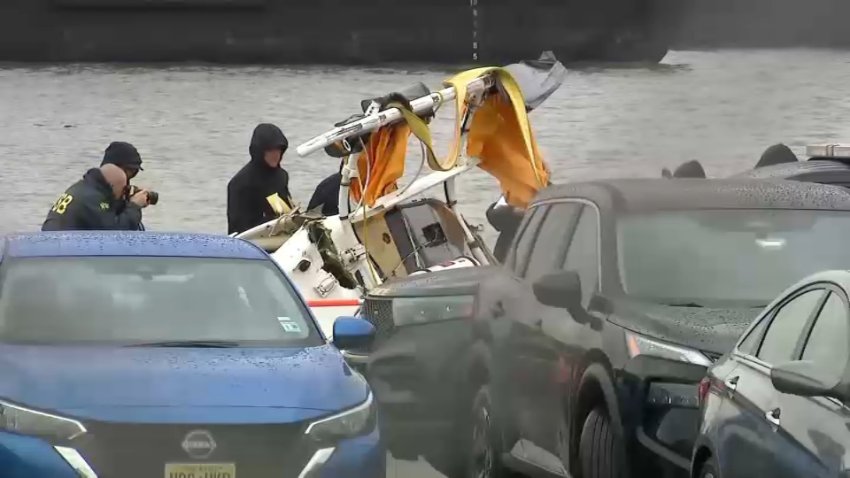 Investigators examine part of the helicopter wreckage the morning after the deadly free fall into the Hudson River.