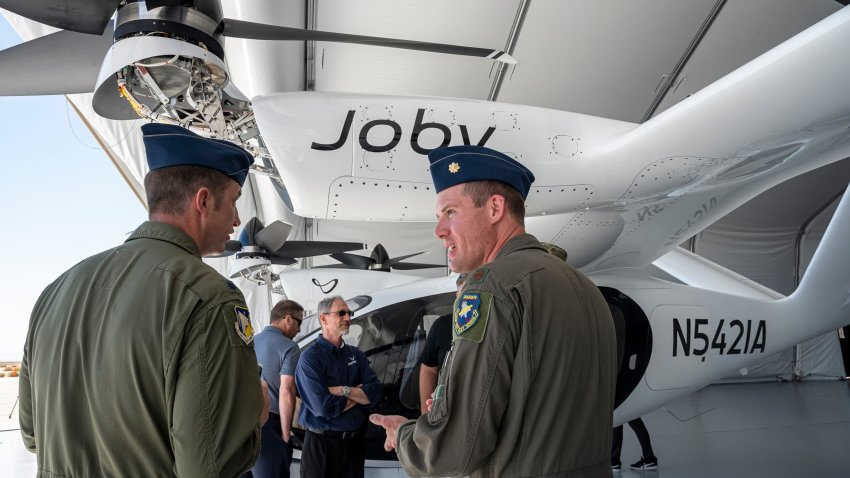 Attendees view a Joby Aviation electric vertical take-off and landing (eVTOL) aircraft during an event at Edwards Air Force Base in Edwards, California, US, on Monday, Sept. 25, 2023. Air taxi start-up Joby Aviation Inc. today announced it has delivered its first eVTOL to the US Air Force. 