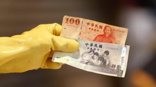 Workers at a wet market count and return New Taiwan Dollar notes to customers, as Taiwan is expected to show positive GDP and economic growth, amid the covid-19 pandemic, in Taipei, Taiwan, 15 Aug 2021.