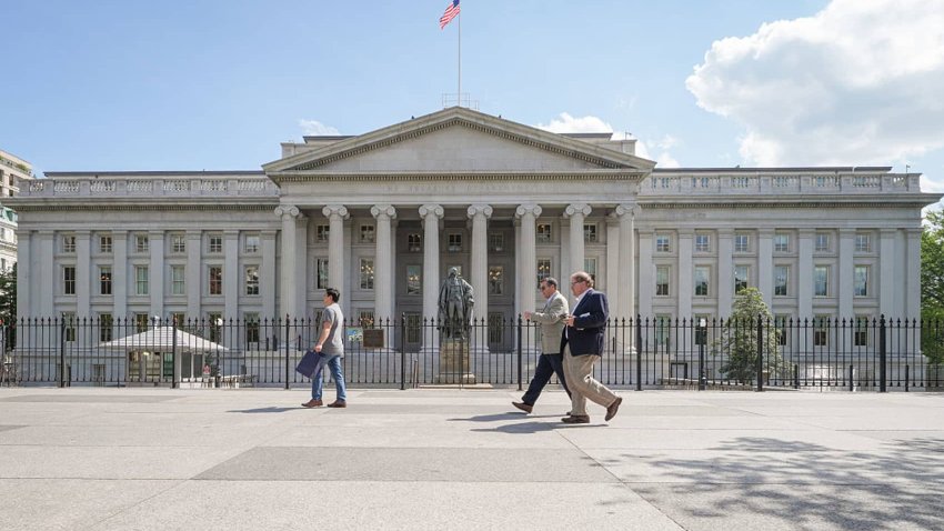 Pedestrians walk past the north entrance to the U.S. Treasury Department headquarters building on April 30, 2025, in Washington, DC.